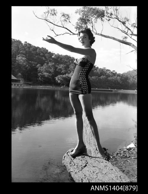 Photographic negative of a swimsuit model posing on a river bank