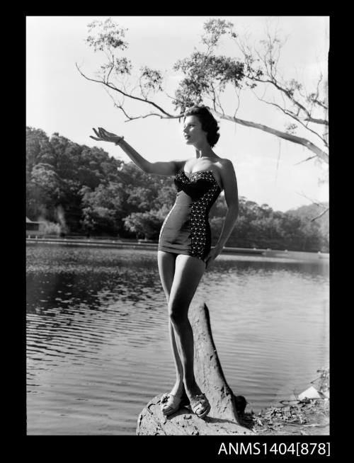 Photographic negative of a swimsuit model posing on a river bank