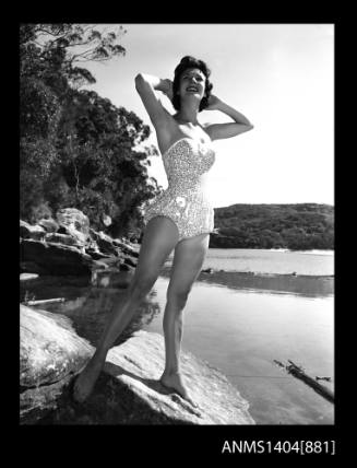 Photographic negative of a swimsuit model posing on a river bank