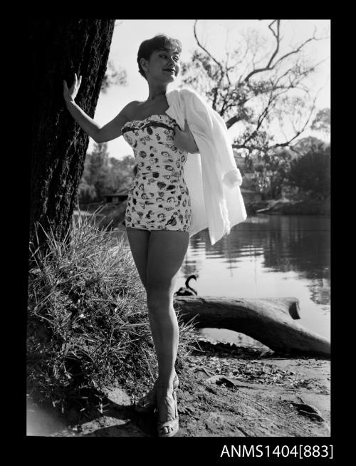 Photographic negative of a swimsuit model posing on a river bank