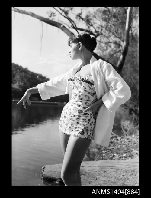 Photographic negative of a swimsuit model posing on a river bank