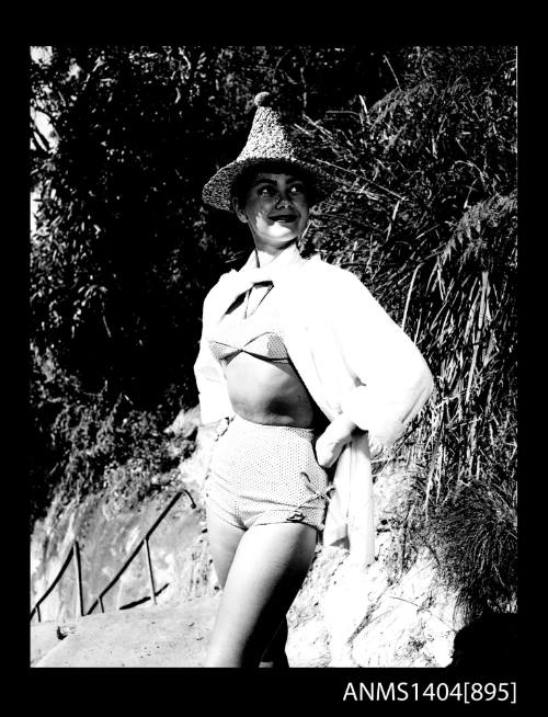 Photographic negative of a swimsuit model posing on a beach