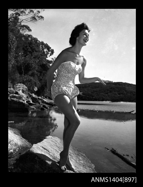 Photographic negative of a swimsuit model posing on a river bank