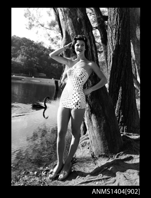 Photographic negative of a swimsuit model posing on a river bank