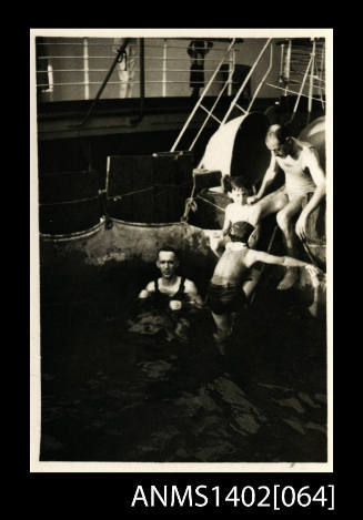 Two men and two children at the side of the swimming pool (E & A Line)