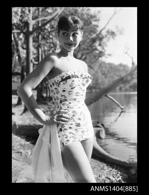 Photographic negative of a swimsuit model posing on a river bank