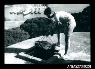 Photocopy of a photograph of a man holding a pearl cage