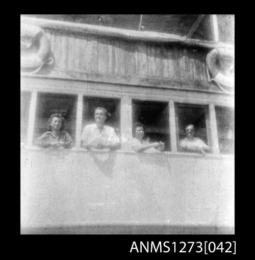 Four people on a boat, looking out of windows