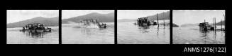 Strip of four black-and-white negatives of a boat in the water, with several people on board, putting tall wood beams into the water