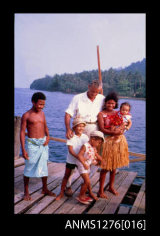 35mm colour transparency of Denis George with his three sons, and a male and female Papua New Guinean