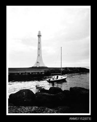 Print depicting small sailing boat using its outboard motor passing on port side marker at entrance to St Kilda Marina, Port Phillip Bay, Melbourne