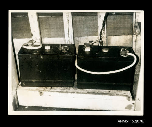 Print depicting two 6-volt car type batteries in power boat