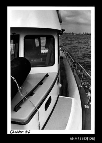 Print depicting port side view of open deck area of a cabin cruiser looking aft