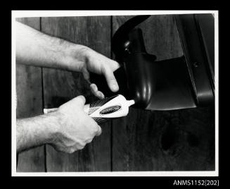 Hands holding a plastic tube of Iekhfaerer Mercury lubricating oil