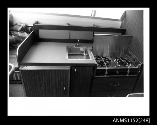 The Interior of cabin on a pleasure craft displaying a new unit containing refrigerator, sink, and, gas stove