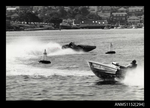 Hydroplanes racing around two marker buoys