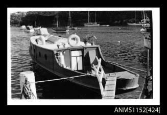 The houseboat moored stern first to wharf