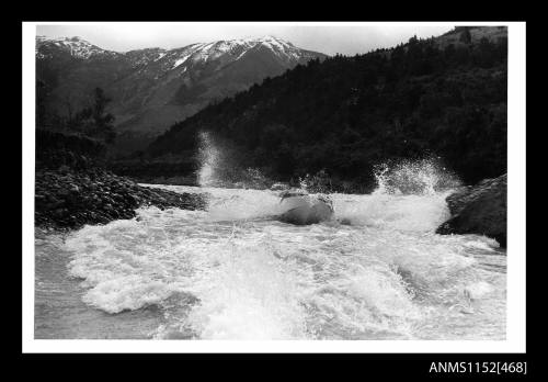 The water jet travelling quickly up stream against rapids passing between two rocky outcrops