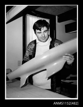 Ben Lexcen holding a model hull of a racing yacht