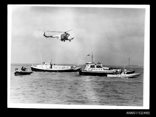 The four emergency response boats with rescue helicopter over head at upper corner