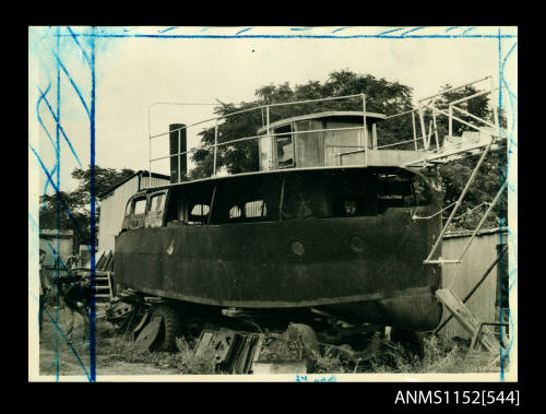 The view of bow section of small iron steam boat resting on motor lorry chassis in a scrap yard