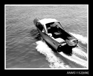 A Savage open power boat with windscreen and canvas canopy open