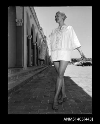 Model wearing white trimmed beach coat at Bondi Pavilion