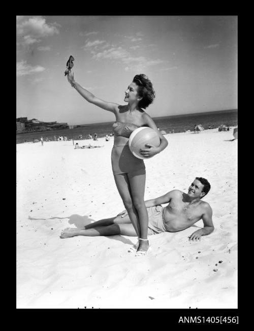 Model with beach ball and sunglasses on Bondi Beach