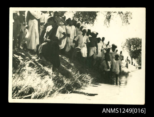 Crowd gathered on grassy river bank