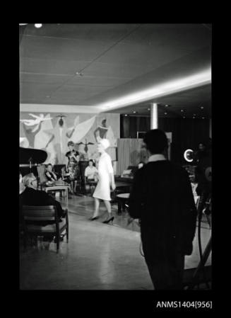 Negative depicting a woman in a studio with a film crew