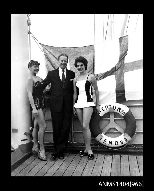 Photographic negative of two swimsuit models posing with a man in a suit