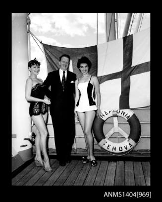 Photographic negative of  two swimsuit models posing by with a man in a suit