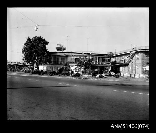 Negative depicting the Golden Gate Motel with two men walking past