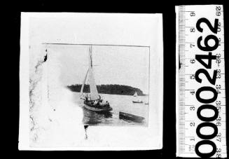 Badly damaged image of a cutter with dinghy on Sydney Harbour