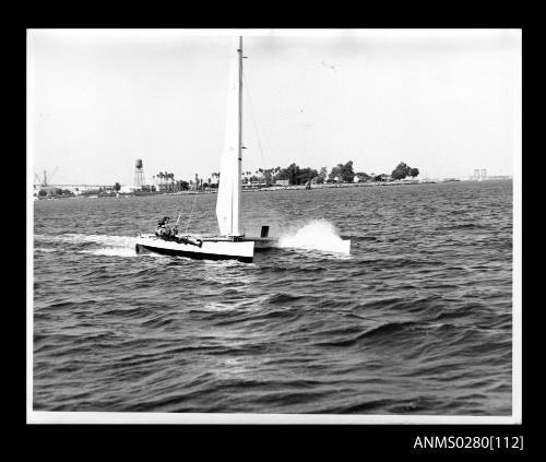 Catamaran PATIENT LADY III sailing with crew member on trapeze off Cabrillo Beach, California  