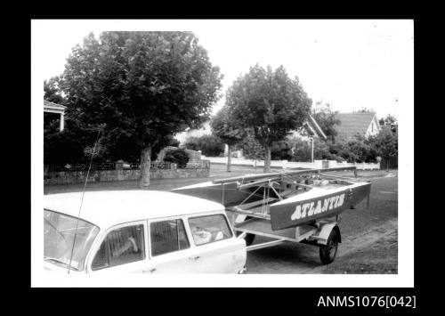 Black and white Prototype ATLANTIS on a trailer attached to a stationwagon