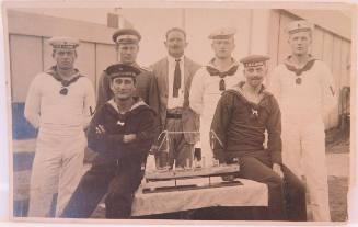 Photographic postcard of SMS EMDEN sailors with ship model