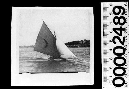 Yacht displaying a crescent moon emblem and the number '47' on the mainsail, Sydney Harbour