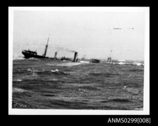 Cargo ship sinking bow first into heavy seas