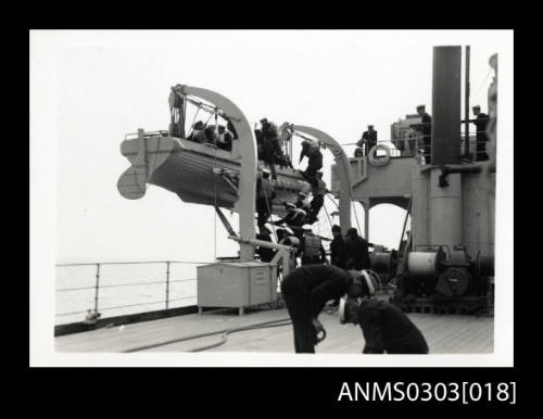 View of deck of HMS KANIMBLA with crew and officers entering lifeboat