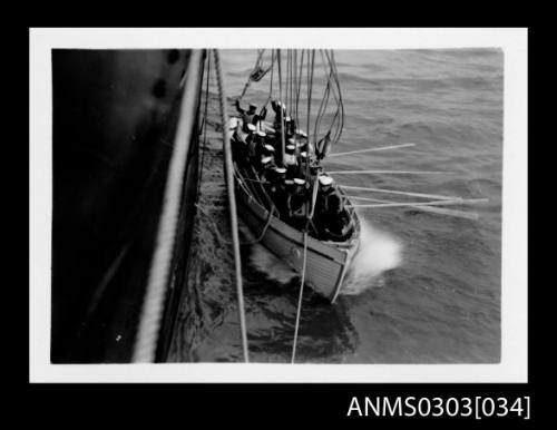 Wooden lifeboatwith crew alongside HMS KANIMBLA