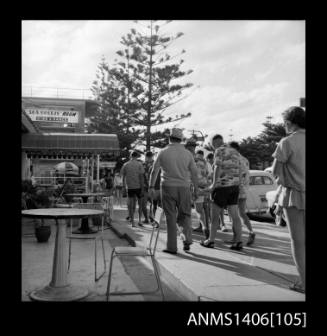 Negative depicting a group of people walking towards a restaurant