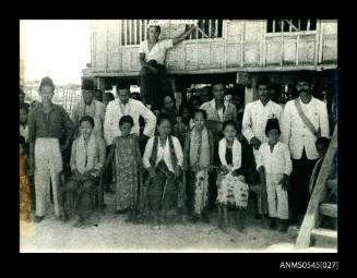 View of residents in front of a stilted house in Indonesia