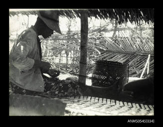 View of a man weaving a fishing net