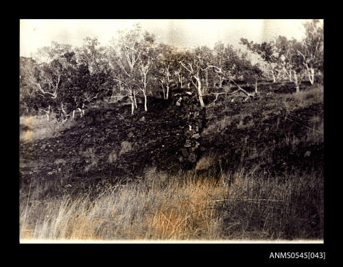 View of people walking down a rocky hill 