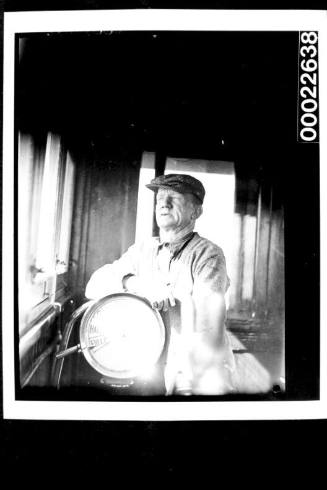 Crewman posing with a ship's telegraph : passenger liner AWATEA