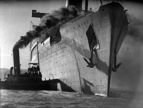 HMT QUEEN MARY assisted by a tug, probably SS HEROIC