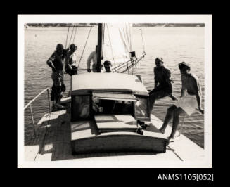 Six people standing on deck of a yacht