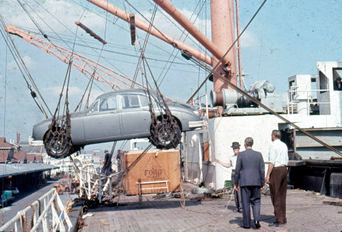 Photographic slide showing a Jaguar car being loaded onto a cargo vessel