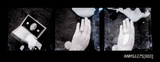 Three negatives, joined together, two of a hand with a piece of pearl jewellery in itand the the third image of a cruciform shaped blister pearl and two half pearls, displayed in a box